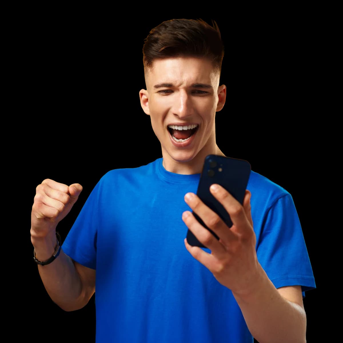 Young man in a blue shirt, excitedly looking at his phone, raising a fist in celebration against a plain background.
